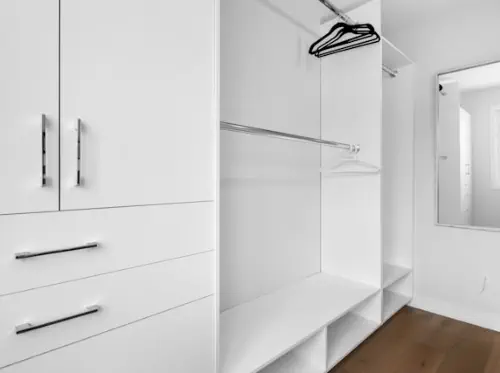 Closeup of a woman's hands. She has taken off her wedding band and is balancing it on a wooden fence rail with the pointer finger of her right hand.